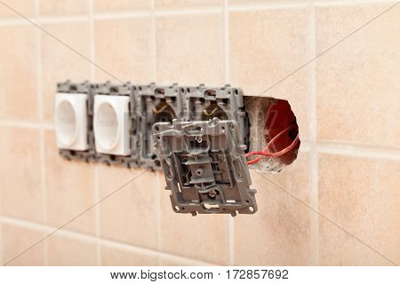 Closeup of a partially installed electrical wall socket - with one of the fixtures hanging on wires