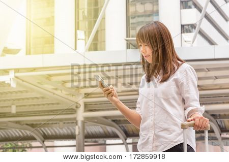 Portrait Of Beautiful Casual Businesswoman Using Smartphone In The City Background