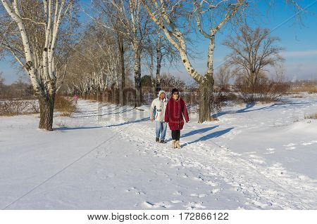 DNEPR UKRAINE - JANUARY 08 2017: People walking in winter park at sunny weekend in Dnepr city Ukraine at January 08, 2017