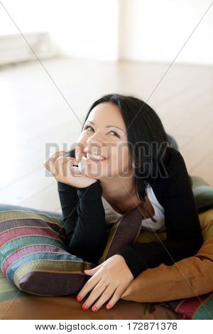 Portrait of a smiling young woman lying on the floo