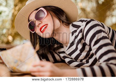 Woman traveler wearing hat holds city map
