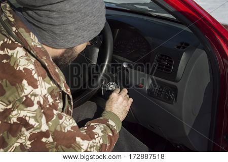 Starting car in the winter. The man in the cap puts the keys in the ignition of the car. 
Starting the car in winter conditions.
