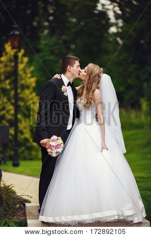 Outstanding Weddding Couple Kisses Walking Around The Park