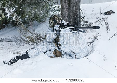 Winter arctic mountains warfare. Action in cold conditions. Sniper with weapons in forest somewhere above the Arctic Circle