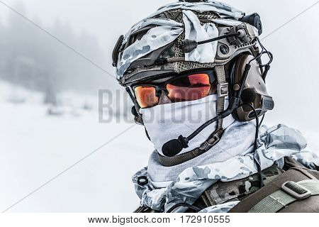 Winter arctic mountains warfare. Action in cold conditions. Trooper with weapons in forest somewhere above the Arctic Circle