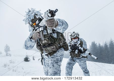 Winter arctic mountains warfare. Action in cold conditions. Pair of special forces weapons in forest somewhere above the Arctic Circle, low angle view