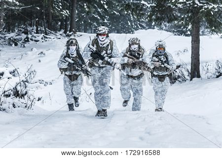 Winter arctic mountains warfare. Action in cold conditions. Squad of soldiers with weapons in forest somewhere above the Arctic Circle