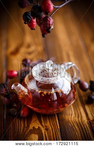 Dried red rose hips and tea on a black background