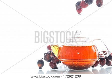 Dried red rose hips and tea on a white background