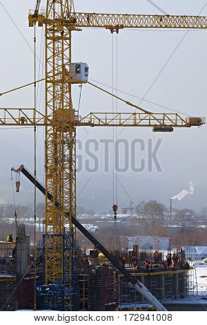 Workers build a building with a crane
