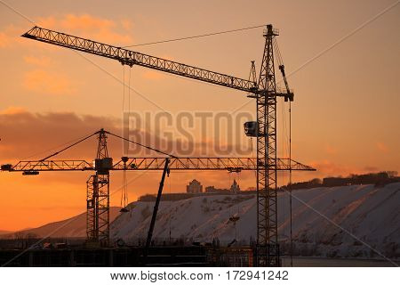 Construction of the building. Construction crane on the sunset background
