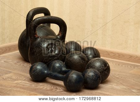Four dumbbells and kettlebells in the gym on the floor