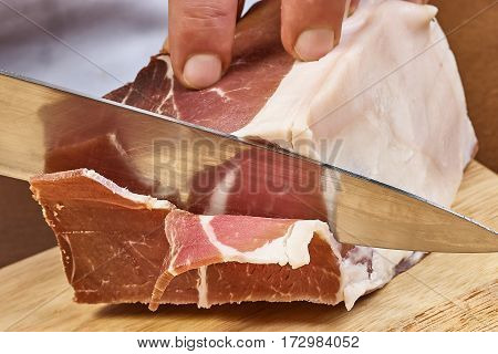 Dry cured ham thinly sliced Closeup on chef hands slices prosciutto Italian delicatessen dishes cooking process