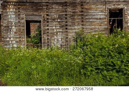 Wooden Wall Of An Old Vintage Russian House Izba With Written Arabic And Roman Numbers In Logs In Or