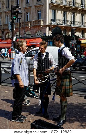 Paris - August 3, 2017: A Man Speaking With Two Young Scotsmen Busking In Paris, France.