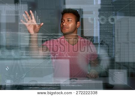 Young Concentrated Indian Data Analyst Looking Over The Data