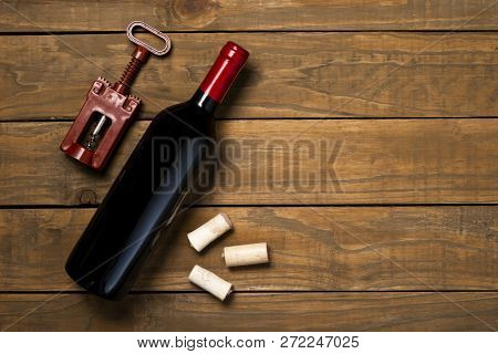 Bottle Of Wine Glass And Corks On Wooden Background. Top View With Copy Space.