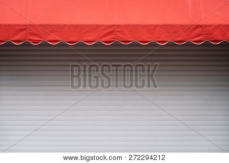 White stall with closed shutters and red sunshade. Geometric contrast background with copy space for text and design