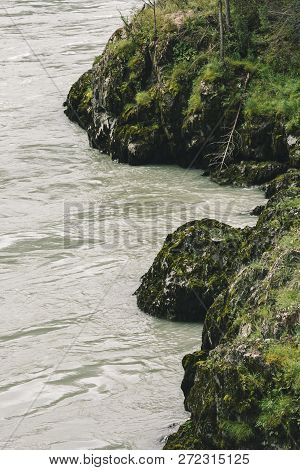 Gloomy View From Above On Rocky Sinuous Riverbank. Dark Green Of Water. Eerie Atmosphere In Overcast
