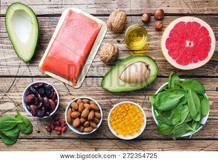 Concept Healthy Food Antioxidant Products: Fish And Avocado, Nuts And Fish Oil, Grapefruit On Wooden