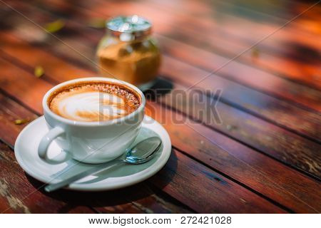 Hot Coffee Latte Cappuccino Spiral Foam On Wooden Table In Coffee Shop Cafe With Vintage Color Tone 