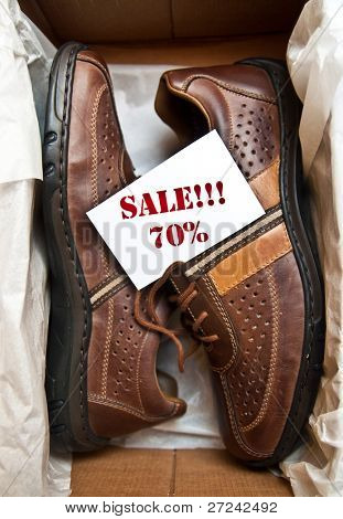Chaussures dans une boîte avec l'étiquette « vente de 70 % »