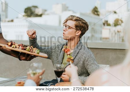 Happy man being served with barbeque skewers