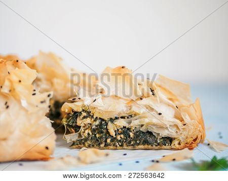 Greek Pie Spanakopita On Blue Table With Shallow Dof. Slice Of Vegetarian Or Vegan Spanakopita Spina