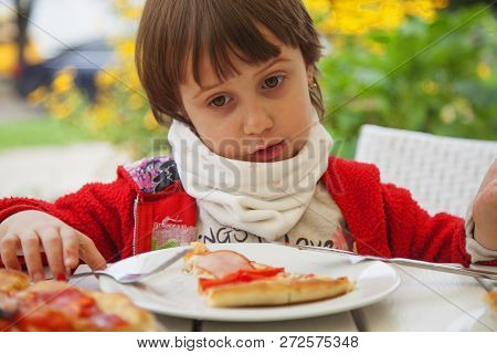 Little Female Child With Pizza Slices In Front Of Their Faces. Happy Cule Little Girl Having Fun Eat