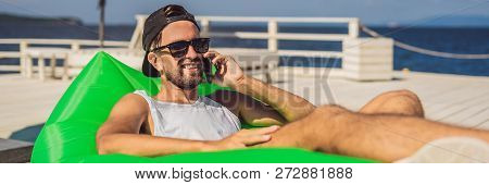 Young Man Enjoying Leisure, Lying On The Air Sofa Lamzac, Near The Sea Banner, Long Format