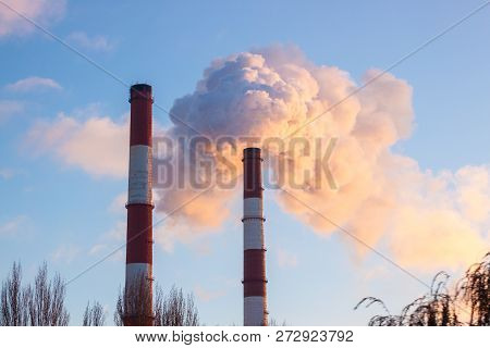 From The Factory Pipe Smoke Runs Into The Blue Sky, The Eology In The City In Ukraine At Sunset.