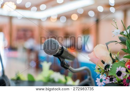 Microphone On Abstract Blurred Of Speech In Seminar Room Or Speaking Conference Hall Light On Stage 