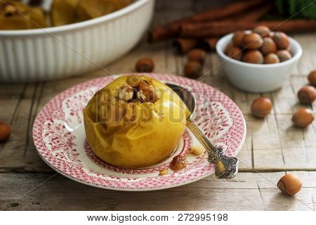 Baked Apples With Raisins, Hazelnuts And Cinnamon On Wooden Background. Rustic Style.