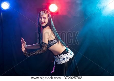 Girl Dancing Belly Dance, Fusion Or Tribal. A Woman In A Beautiful Costume Demonstrates Charming And