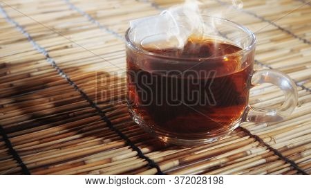 Hot Tea In Clear Glass On A Woven Wooden Floor