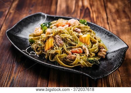 Spinach Fettuccine Pasta With Beef And Vegetables On The Wooden Table, Horizontal
