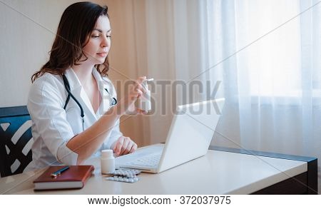 Close-up Of The Doctors Hand A Handful Of Spray, Pills, Medications, Medications, Tablets. Laptop On
