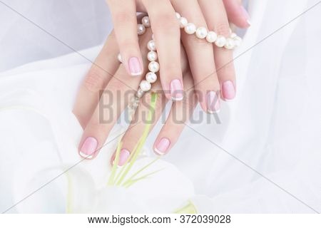 Female Hand With French Manicure On A White Background.