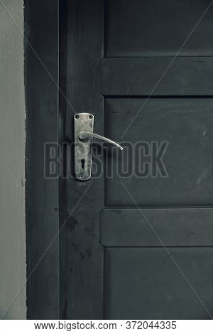 Monochrome Image Of An Old Wooden Door With Steel Handle.