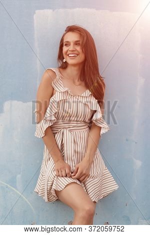 Portrait Of A Young Smiling Woman Near Blue Wall Outdoor