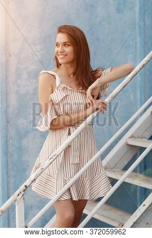 Portrait Of A Young Smiling Woman Near Blue Wall Outdoor