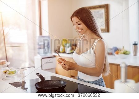Young Beautiful Woman Cooking Breakfast At Home