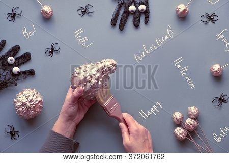 Creative Halloween Flat Lay On Grey Paper Background With Copy-space. Hands Coloring Decorative Pump