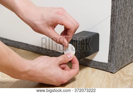 Man Are Sticking Floor Care Pad At Bed Wooden Legs. Anti-skid Felt Pad Cover Install On Wooden Furni