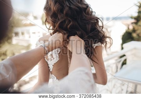 Portrait Of Bride Wearing Dress By Her Mom Outdoors. Beautiful Hair