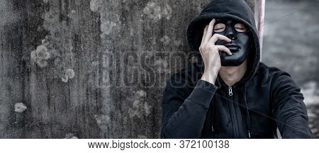 Mystery Man In Black Mask With Hoodie Jacket Sitting On Abandoned Building Feeling Tired And Stresse