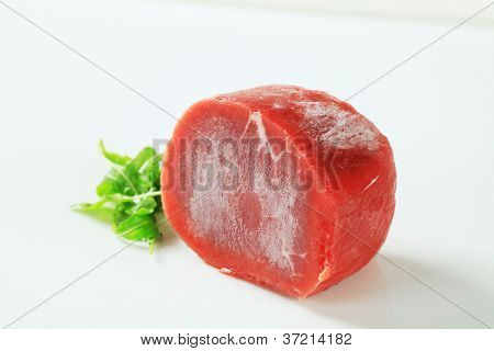 Carni bovine congelate con erbe aromatiche su sfondo bianco