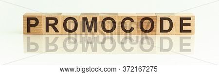 Wooden Blocks With The Text: Promocode. The Text Is Written In Black Letters And Is Reflected In The