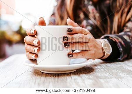 Woman Hand Holding A Cup Of Coffee Outdoors At Coffee Shop Or Cafe With Blurred Background