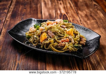 Spinach Fettuccine Pasta With Beef And Vegetables On The Wooden Table, Horizontal